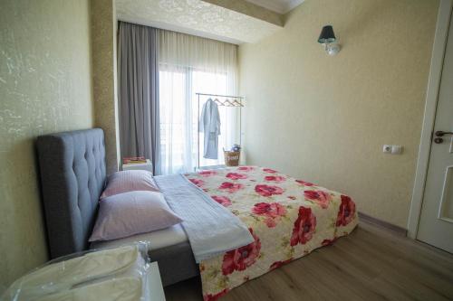 a bedroom with a bed and a window at Comfy Apartment in Tbilisi City