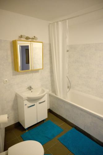 a bathroom with a sink and a toilet and a tub at Haus Alfina in Alf