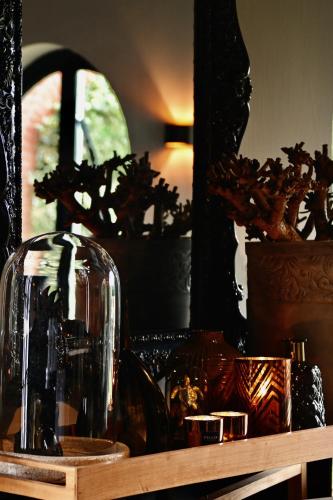 a shelf with a glass vase and a mirror at Hotel Ten Lande in Beernem