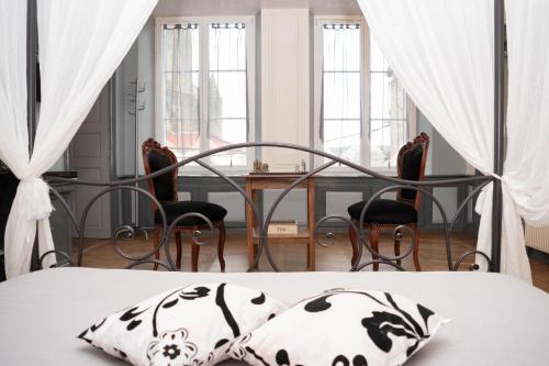 a bedroom with a bed and a table and chairs at La Fée Maison in Châtel-sur-Moselle