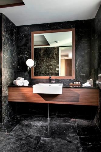 a bathroom with a sink and a mirror at Hougoumont Hotel Fremantle in Fremantle