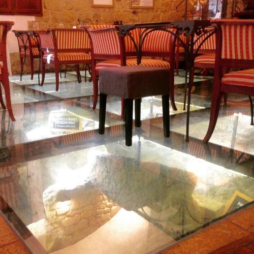 a glass table and chairs and a glass table and chairs at Appartamento Matteotti in Volterra