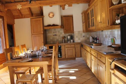 a kitchen with wooden cabinets and a table and chairs at La Ferme de Sous-Lachat in Samoëns