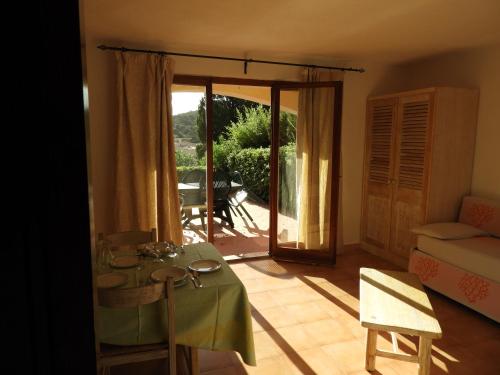 een woonkamer met een tafel en een glazen schuifdeur bij Chrysalis Bay in Porto Cervo