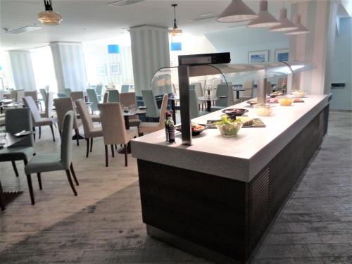 a restaurant with a counter with food on it at Hotel Santana in St Paul's Bay