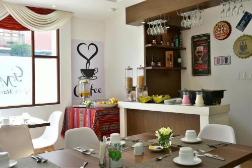 a dining room with a table and a kitchen at Hotel Gran Mariscal Quito in Quito
