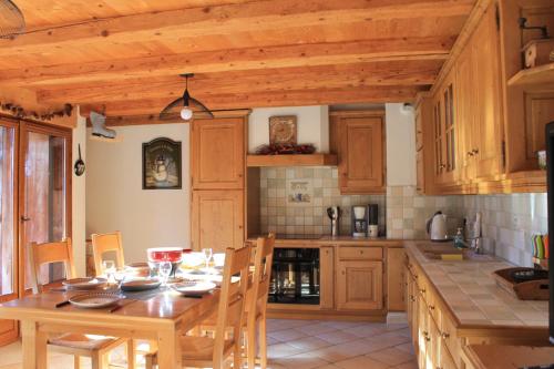 a kitchen with a wooden table and a wooden ceiling at La Ferme de Sous-Lachat in Samoëns