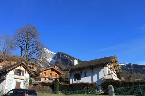 a white house with a mountain in the background at La Ferme de Sous-Lachat in Samoëns
