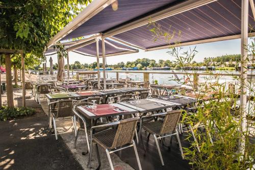 a group of tables and chairs with a view of the water at Les chambres de la Cotinière - Bord de Saône - St Jean de Losne in Saint-Jean-de-Losne