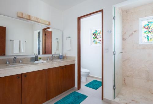 a bathroom with two sinks and a shower and a toilet at Casa Sienna Lia Spacious House in Isla Mujeres