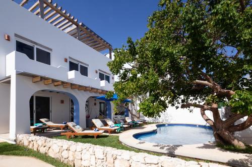 a villa with a swimming pool and a tree at Casa Sienna Lia Spacious House in Isla Mujeres