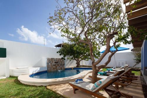 a swimming pool with a tree in a yard at Casa Sienna Lia Spacious House in Isla Mujeres