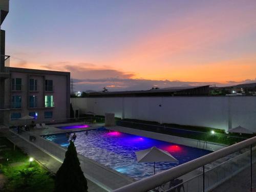 a large swimming pool with colorful lights on a building at Hotel Las Olas Palermo in Neiva