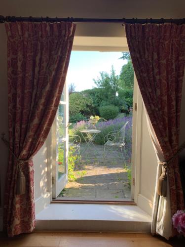 an open door with a view of a garden at Cary Fitzpaine House in Babcary