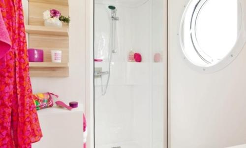 une salle de bain avec douche et miroir dans l'établissement Camping Les Chèvrefeuilles - Maeva, à Royan