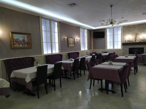 a dining room with tables and chairs and a fireplace at VLG Hotel in Boryspil