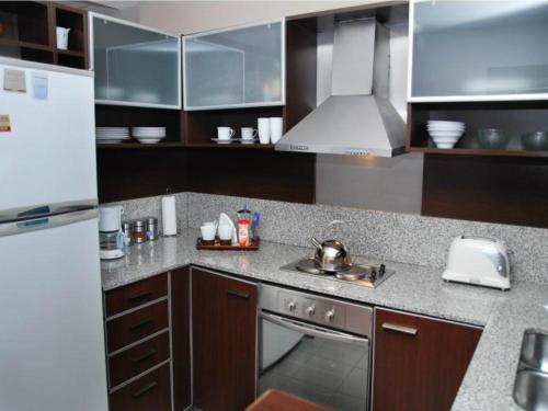 a kitchen with a sink and a refrigerator at Apartment Santa Fe Plaza in Buenos Aires