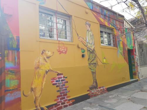 a mural of a man and a dog on the side of a building at Palermo Viejo Bed & Breakfast in Buenos Aires