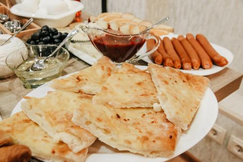 einen Teller mit Lebensmitteln auf einem Tisch mit Hot Dogs in der Unterkunft City Heart Hotel in Tbilisi City