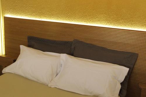 a bed with two white pillows on top of it at Pousada Flay 7 minutos Próximo do Aeroporto de Florianópolis in Florianópolis