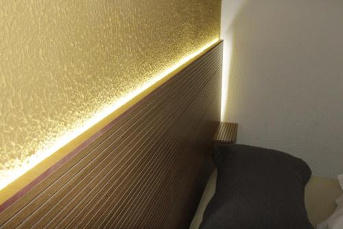 a bedroom with a gold accent wall with a radiator at Pousada Flay 7 minutos Próximo do Aeroporto de Florianópolis in Florianópolis