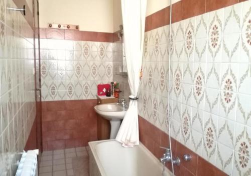 a bathroom with a tub and a toilet and a sink at locazione turistica serena in Riposto