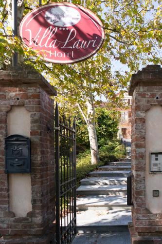 a sign for a villa ranch hotel next to a gate at Hotel Villa Lauri in Neive