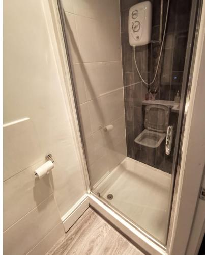 a shower with a glass door in a bathroom at Pilkingtons Guest House Accrington in Accrington