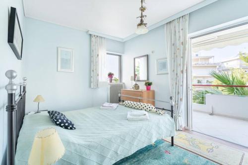 アテネにあるTwo Bedroom Apartment Near Alimos Marina !のベッドと大きな窓のある寝室