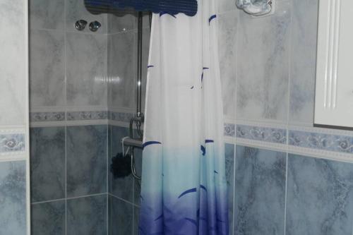 a shower with a blue and white shower curtain at Casa Antony in San Miguel de Salinas