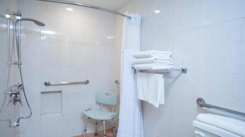 a bathroom with a shower and a toilet and towels at Holiday Inn Ciudad Del Carmen, an IHG Hotel in Ciudad del Carmen