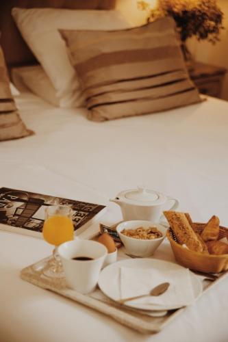 a tray with breakfast foods on a bed at Arcadie Montparnasse in Paris