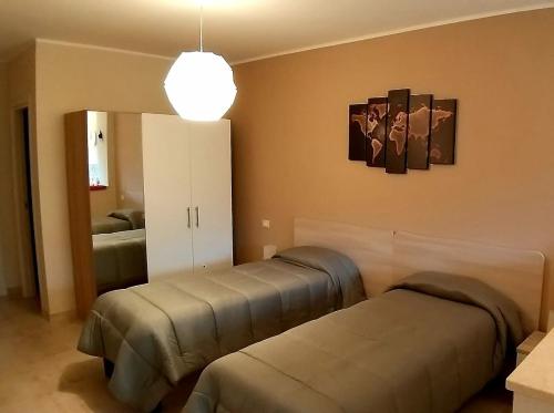 卡斯楚維拉里的住宿－B&B GIRAMONDO，一间卧室配有两张床和镜子