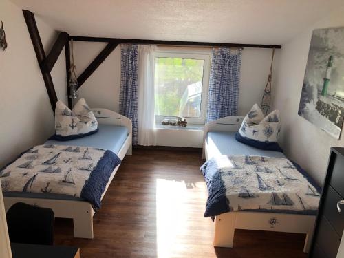 two beds in a room with a window at Ferienwohnungostseeblick in Börgerende-Rethwisch
