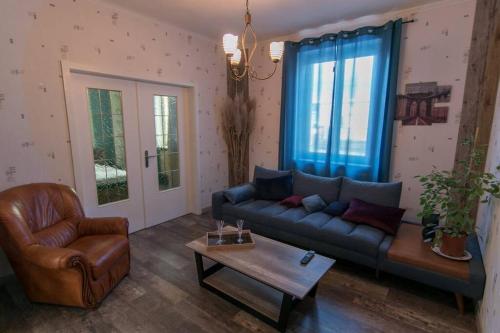 a living room with a blue couch and a chair at auberge du tempo in Riedisheim