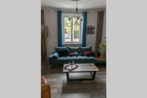 a living room with a blue couch and a coffee table at auberge du tempo in Riedisheim