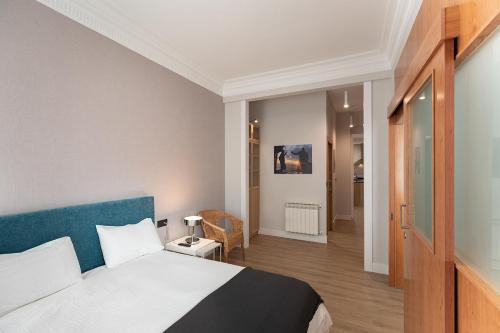 1 dormitorio con 1 cama con cabecero azul en Alameda Recalde Centro en Bilbao