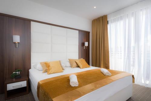 um quarto com uma cama grande com duas toalhas em Hotel Perla em Rogoznica