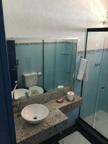 y baño con lavabo, aseo y espejo. en Hotel Icaraí en Itaparica Town