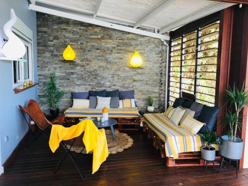 a patio with two beds and a table and chairs at Nolitha 2 in Manapany-les Bains