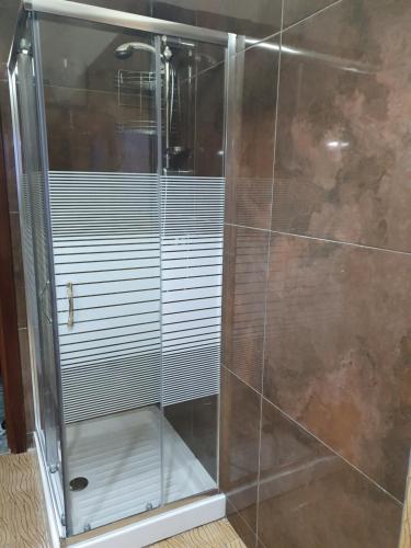 La salle de bains est pourvue d'une douche avec une porte en verre. dans l'établissement Capri View, à Torre del Greco