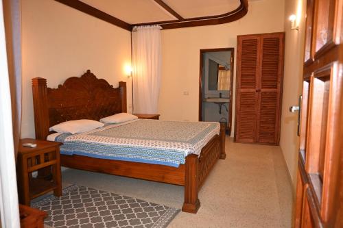 Un dormitorio con una cama con marco de madera. en Tembo Court Apartment 164, en Malindi