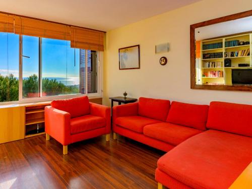 シッチェスにあるApartment Vallpineda San Fermin by Interhomeのリビングルーム(赤いソファ2台、窓付)