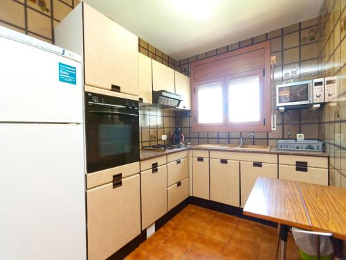 a kitchen with white cabinets and a table in it at Holiday Home Angel Guimera by Interhome in Creixell