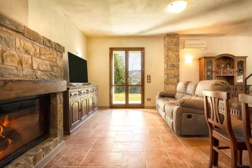 a living room with a couch and a fireplace at Villa Viktoria & Andras in Tredozio