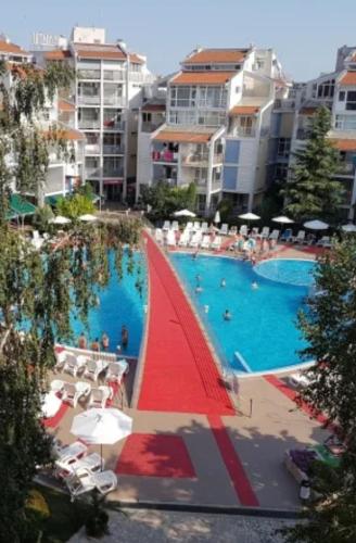 a large swimming pool with a red sail boat in it at Beautiful Penthouse Apartment in Sunny Beach