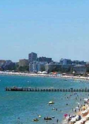 a beach with a pier and people in the water at Beautiful Penthouse Apartment in Sunny Beach