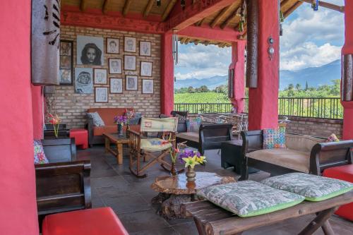 a porch with couches and chairs and a table at Hotel Campestre Solar De La Luna in Armenia