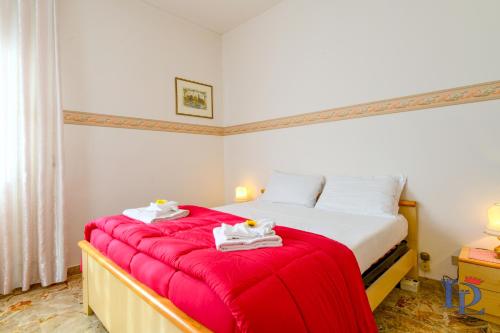 een slaapkamer met een bed met een rode deken bij DesenzanoLoft Il girasole del Lago in Desenzano del Garda