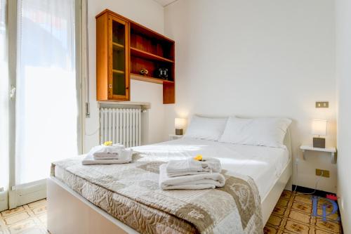 een slaapkamer met een wit bed en handdoeken bij DesenzanoLoft Il girasole del Lago in Desenzano del Garda